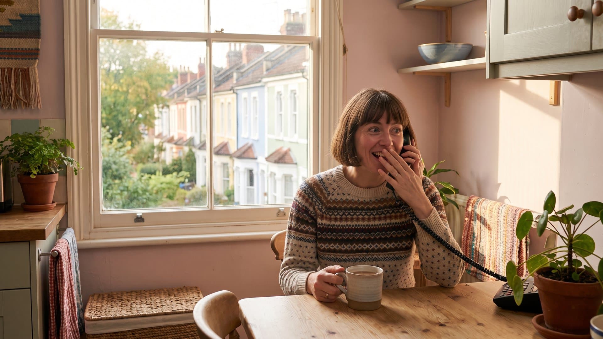 A woman at home delighted by a phone call